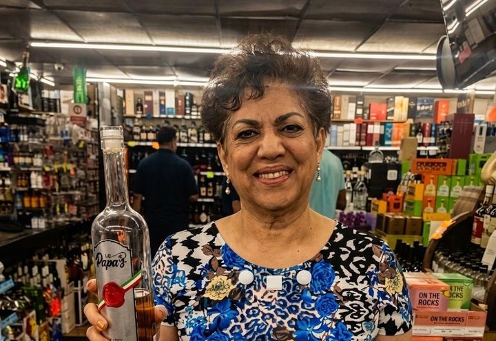 Guest with a bottle of Papa's Grappa at an in-store tasting